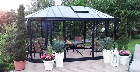 Frittstående utestue i aluminium og glass i hagen